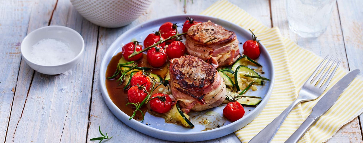 Schweinemedaillons im Speckmantel mit gerösteten Tomaten und Gemüse von der Zucchini für 4 Personen von lidl-kochen.de