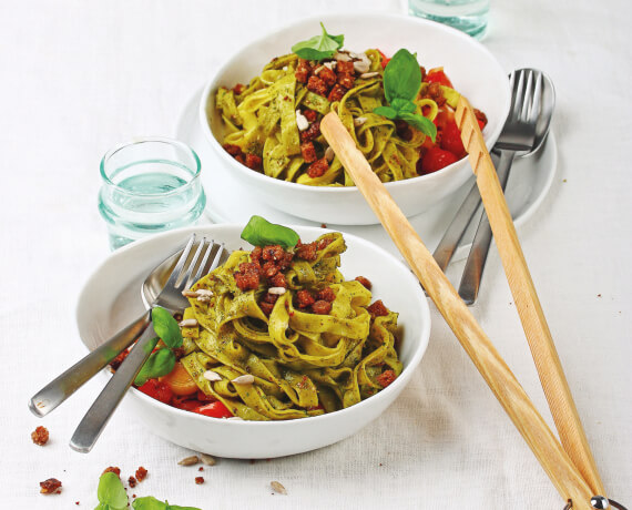 Tagliatelle mit frischem Pesto vom Basilikum und Gemüse aus Lauch und Tomaten