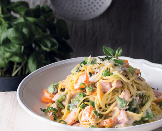 Spaghetti mit Schinken und buntem Gemüse in Käse-Sahne-Sauce