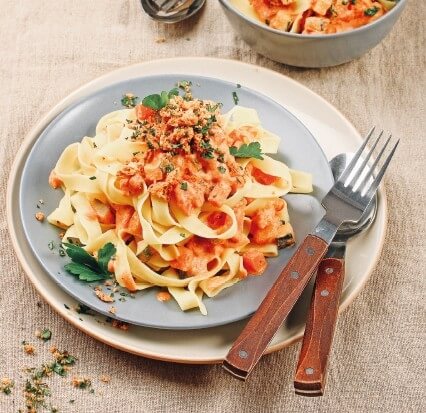 Tagliatelle mit cremiger Frischkäse-Tomaten-Sauce und Kräuterknusper