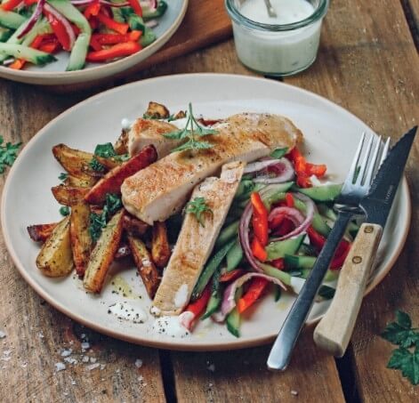 Steaks, knackiger Gurken-Paprika-Salat und Kartoffelwedges