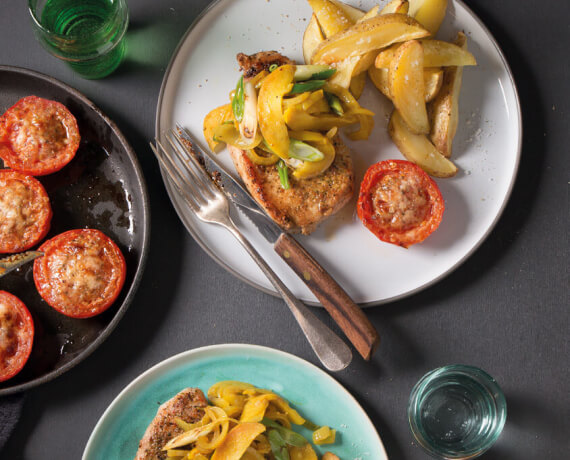 Schweine-Steak mit Apfel-Curry-Zwiebeln, Ofenkartoffeln und würzig gegrillter Tomate