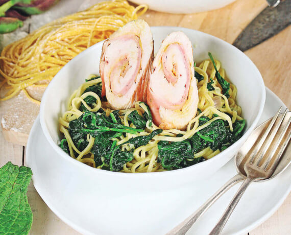 Spaghetti mit Puten-Schinken-Röllchen auf rahmigen Spinat