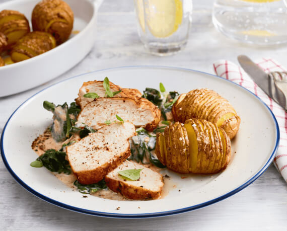 Gebratenes Hähnchen mit Spinat an Sahne-Weißweinsoße auf Hasselback-Kartoffeln