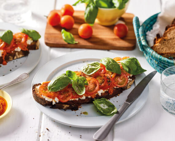 Brot mit körnigem Frischkäse, rotem Pesto und Tomaten