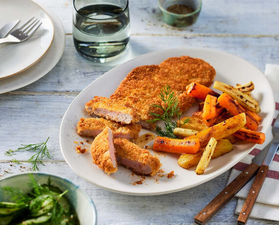 Paniertes Schnitzel mit bunten Pommes und Gurkensalat