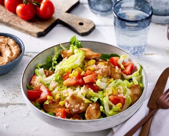 Hähnchenstreifen mit BBQ-Dip auf buntem Salat