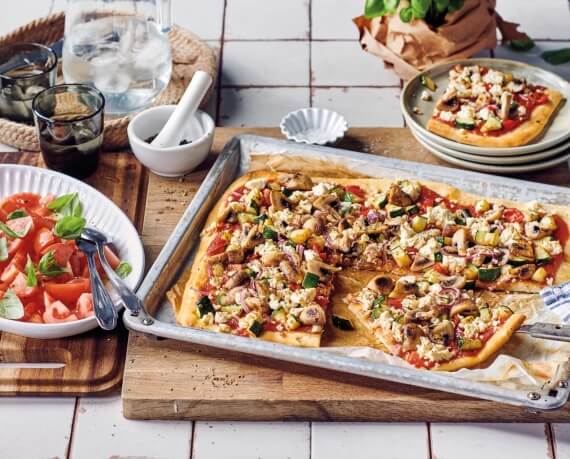 Pizza mit Anti-Pasti-Gemüse, Hirtenkäse und Tomatensalat