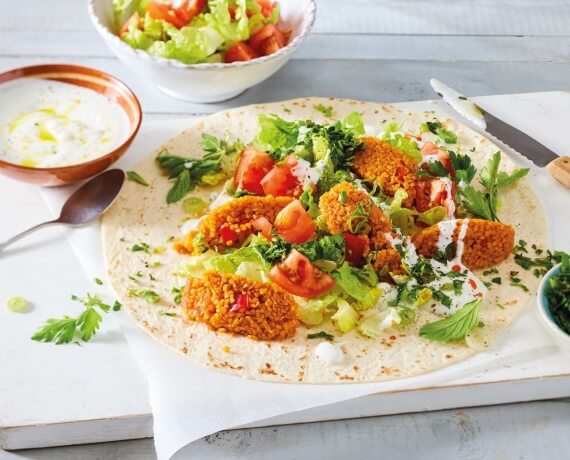 Vegetarische Çiğ-Köfte in Wraps mit Joghurt, Salat und Tomaten