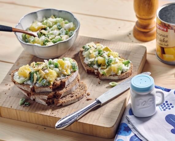 Veganer Lauch-Salat mit Genießerscheiben und Ananas auf Bauernbrot