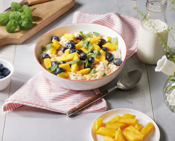 Porridge mit Mango und Blaubeeren