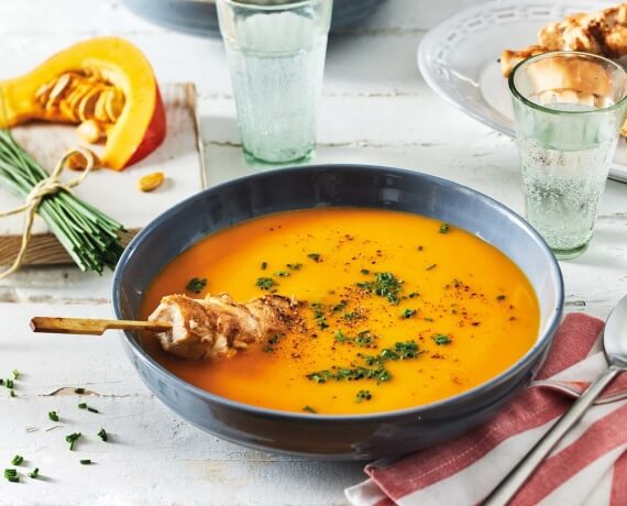 Kürbissuppe mit Schnittlauch an Erdnuss-Hähnchen-Spießen