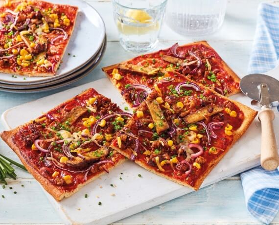 Vegane BBQ-Pizza mit Räuchertofu, Hack, roten Zwiebeln und BBQ-Sauce