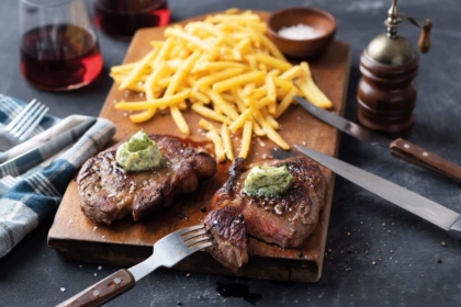 Pommes und Fleisch auf einem Schneidebrett