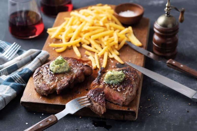 Pommes und Fleisch auf einem Schneidebrett