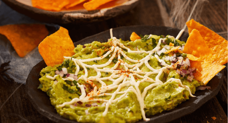 Spinnennetz-Guacamole mit Avocado, Nachos und Crème fraîche