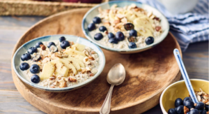 Overnight Oats mit Haferdrink mit Beeren, Apfelspalten und Nüssen