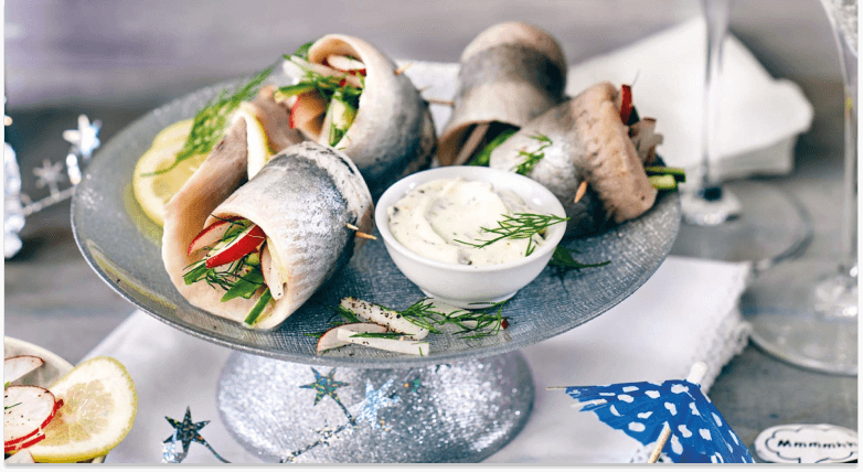 Matjes-Röllchen mit Radieschen und Creme auf Servierteller