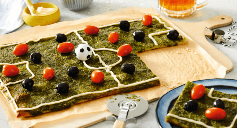 Fußball Pizza mit Tomaten, Oliven und Rucola