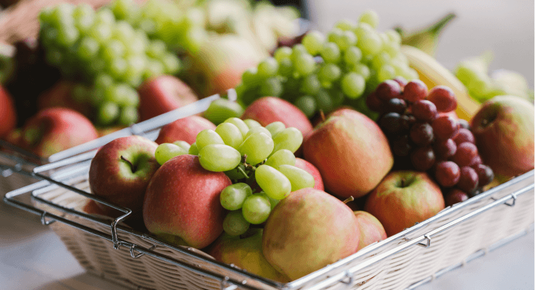 Obstkorb mit Trauben, Äpfeln und Bananen