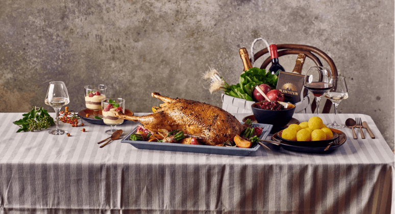 Festliches Weihnachtsmenü mit Gans, Knödeln und Wein