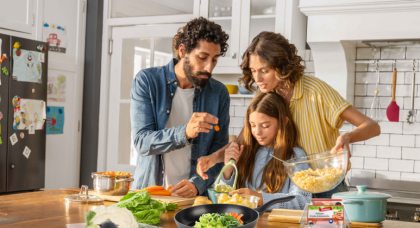 Familie aus Mutter, Vater, Tochter beim gemeinsamen Kochen