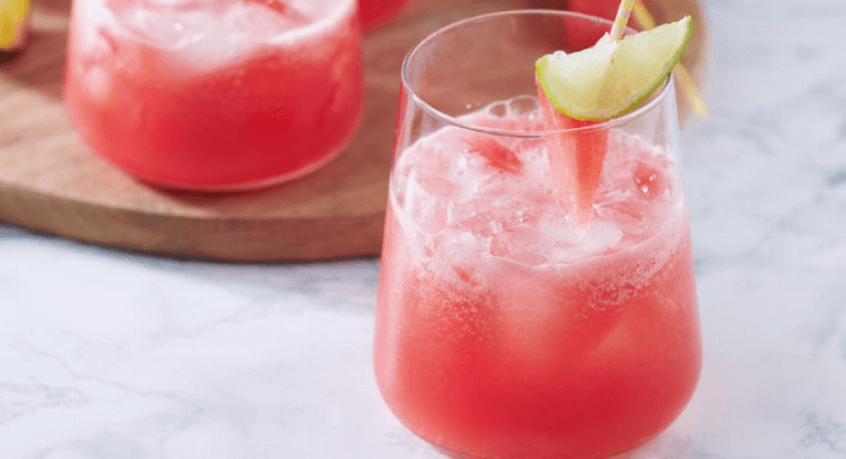 Wassermelonen-Drink mit Limette und Eiswürfeln im Glas