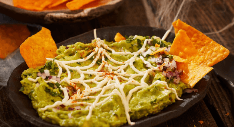 Guacamole mit weißem Spinnennetz aus Crème fraîche